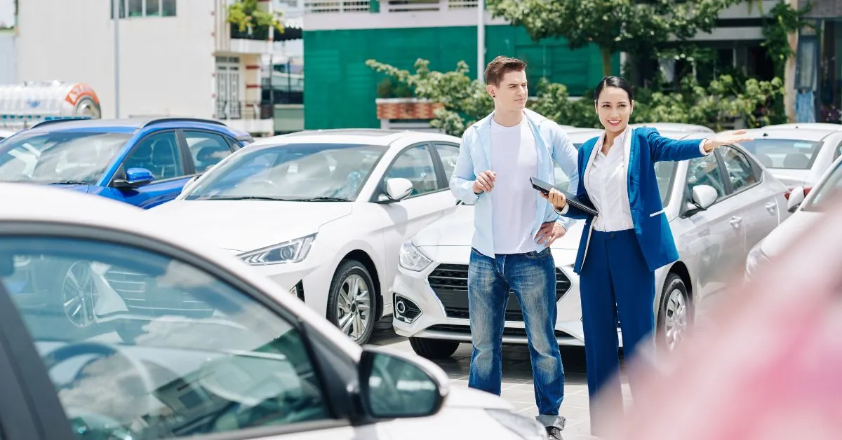 man and saleswoman in a dealership lot. From Sales to Service: How Autosoft DMS Drives Success for Low-Volume Dealerships